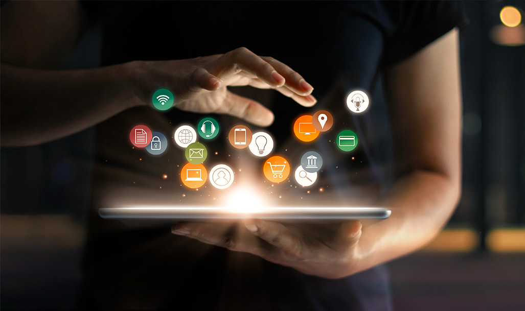 Marketing Professional hand over tablet with icons flying out