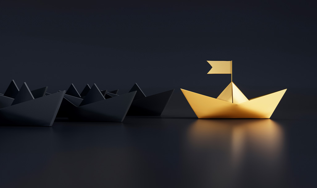 Gold paper ship leading a few black paper ships