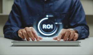 Business person pointing to ROI on laptop screen